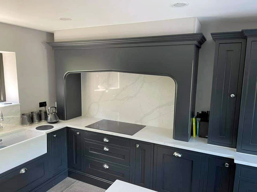 A charcoal in-frame kitchen with a mantel canopy over the hob