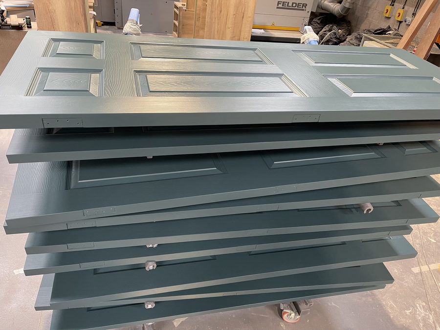 A batch of painted six-panel doors, ready to go out