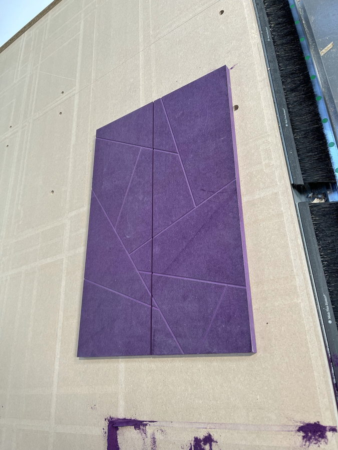 A decorative groove pattern machined into coloured board