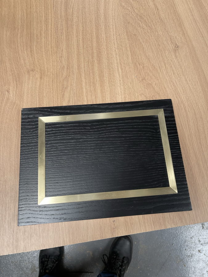 A reeded panel with a mitred brass inlay border