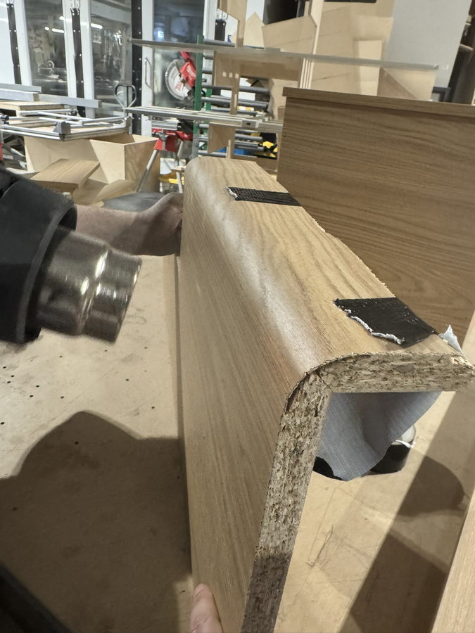 Forming a rounded edge on a veneered panel