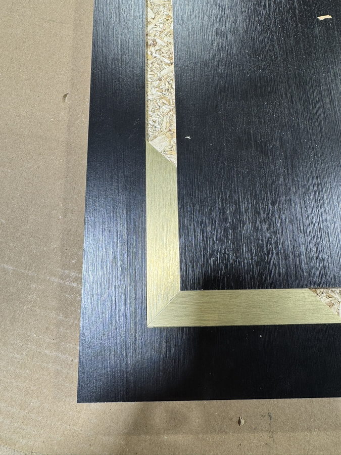 The same detail: a wide brass border on a stained panel