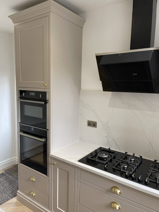Tall oven housing with cornice, brass cup handles and an angled extractor