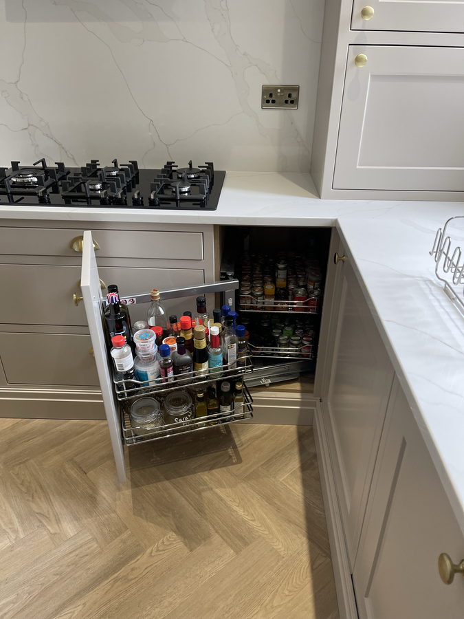 A pull-out spice and bottle rack, tucked in beside the hob