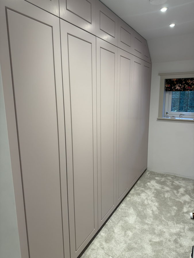 Grey panelled wardrobe doors across the full width of the room