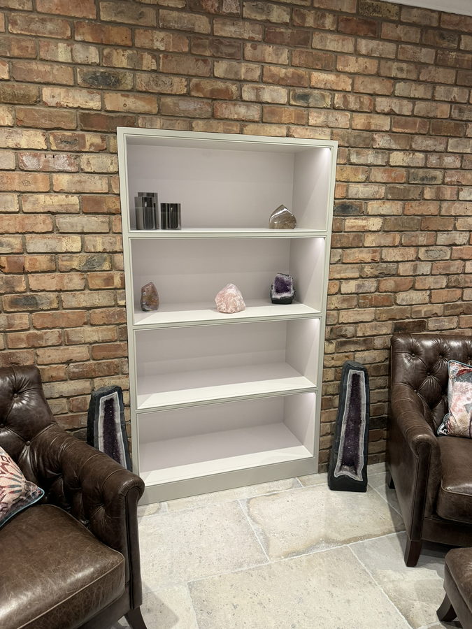 The matching alcove bookcase on the exposed brick wall