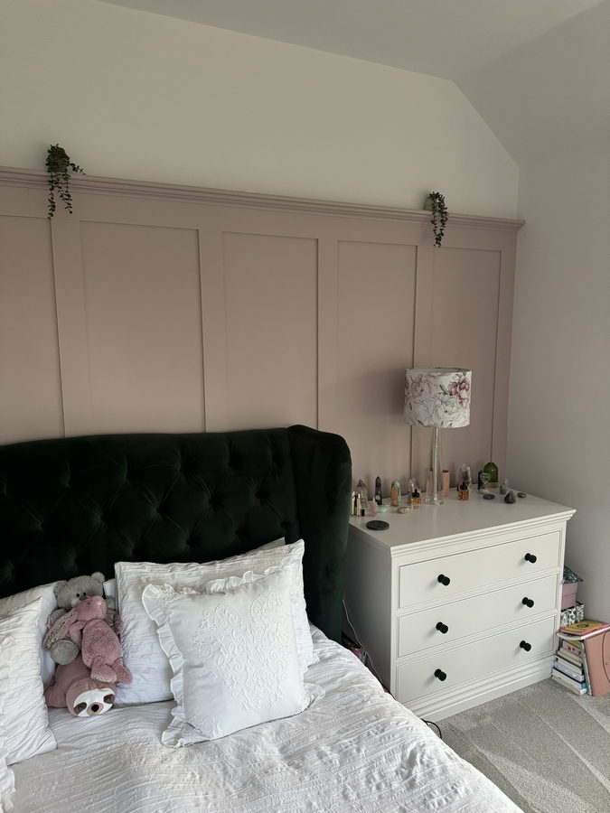 Painted wall panelling behind a bed