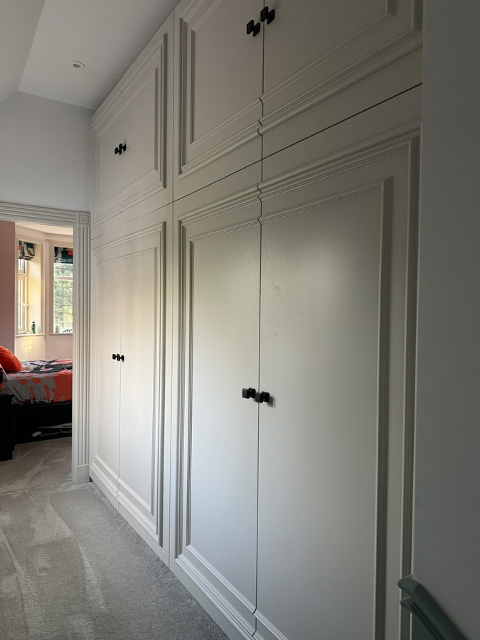 Floor-to-ceiling cream shaker doors with overhead lockers