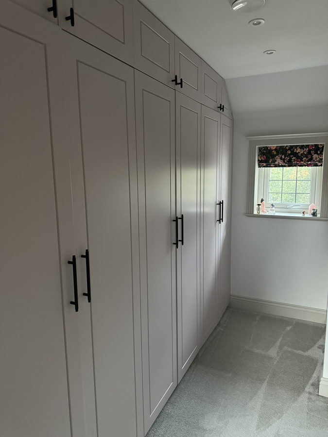 A wardrobe run taken into the eaves, with a window seat between
