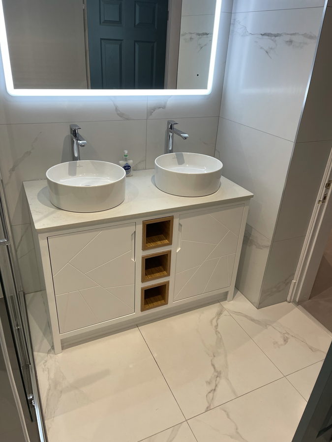Twin round basins, oak cubbies and a backlit mirror
