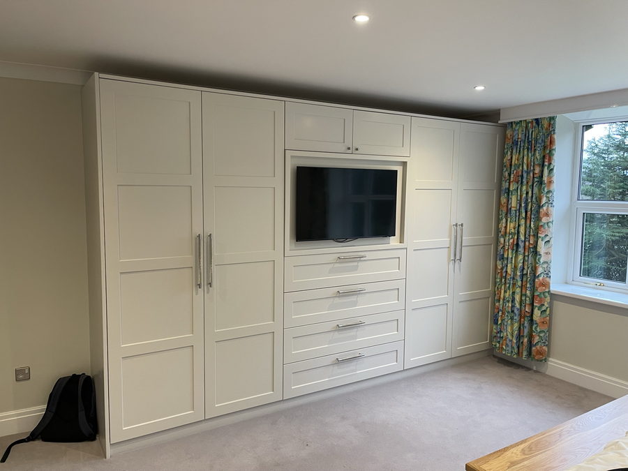 A television let into the wardrobe wall over a bank of drawers