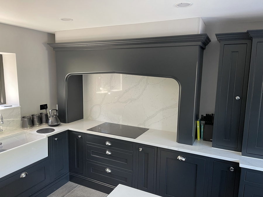 A charcoal kitchen with a painted oak mantel over the hob
