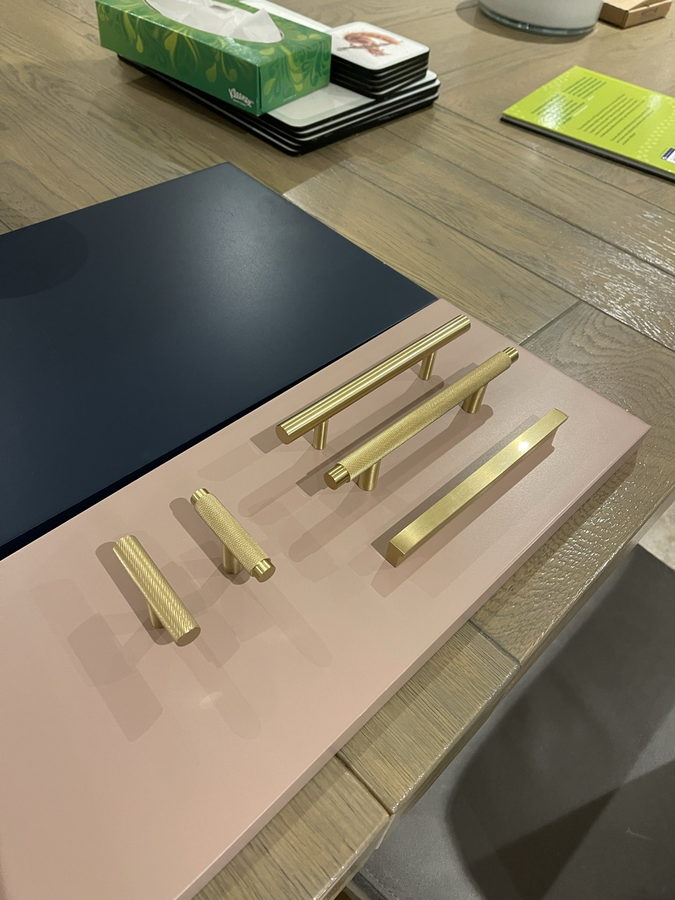Brass handle samples laid on painted colour boards for a customer to choose from