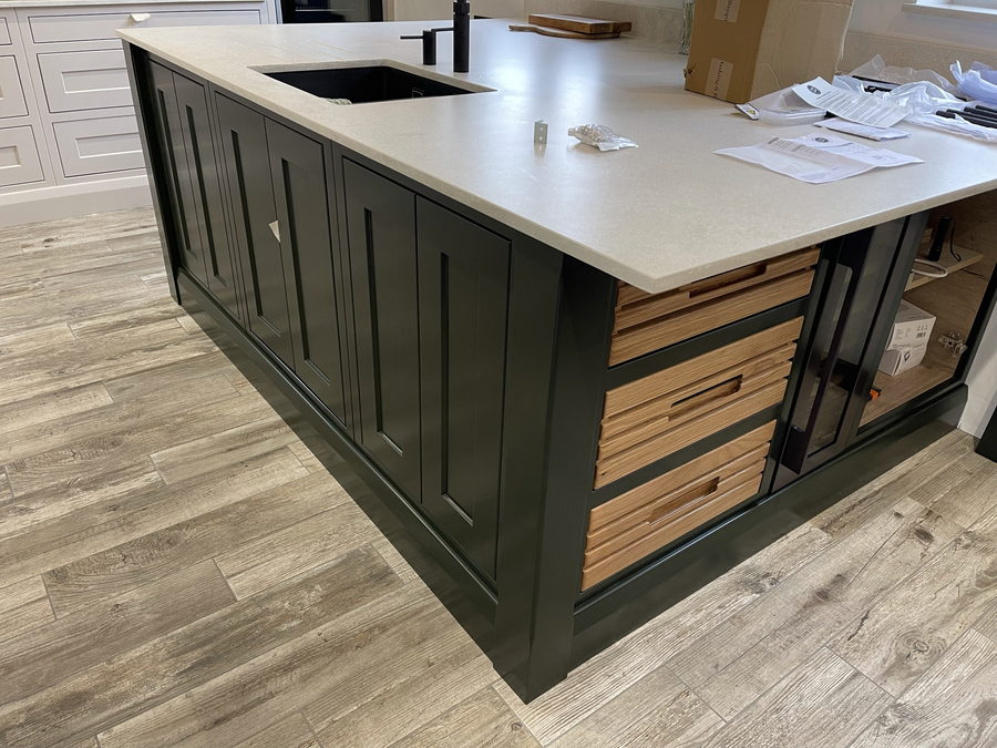 The green island straight on, with oak spice drawers and a glazed end