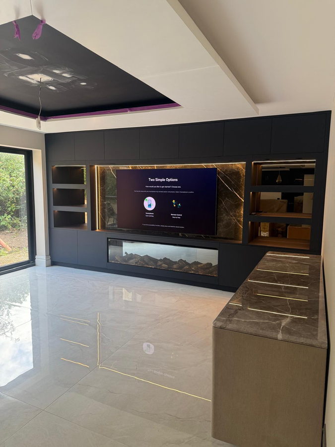 Brass-framed display niches either side of the television