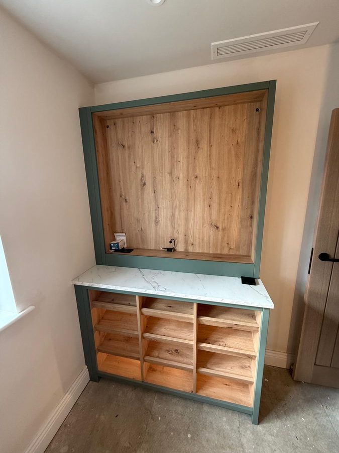 A framed alcove unit with an oak-lined back and cubby shelving