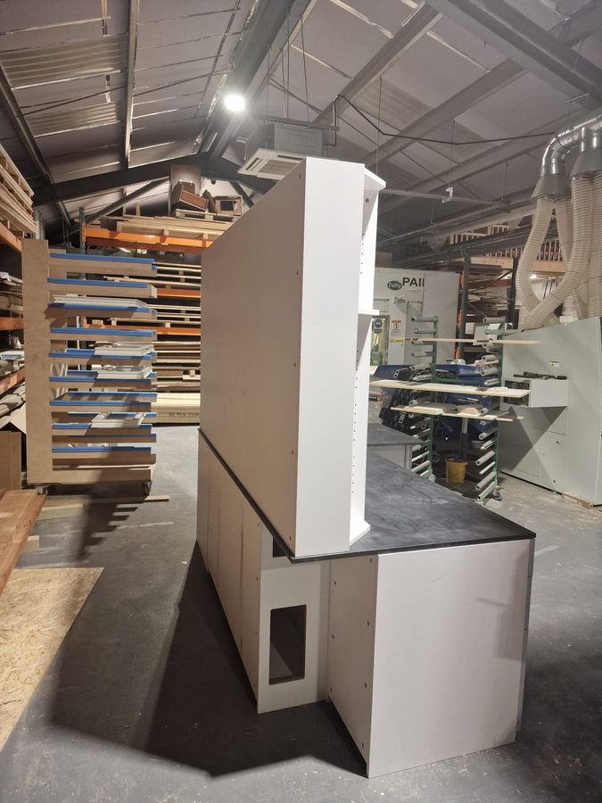 A curved island carcass under build in front of the timber racking