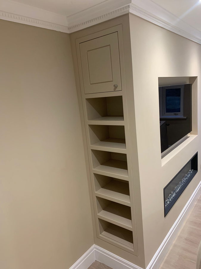 Chimney-breast joinery with a shelf niche, recessed television and fire