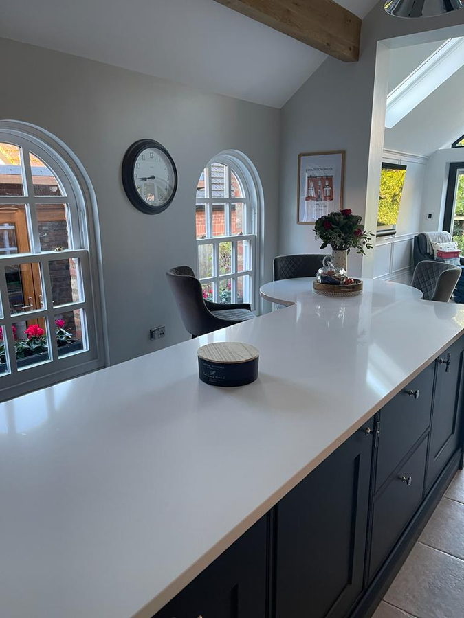 A navy in-frame peninsula under arched cottage windows
