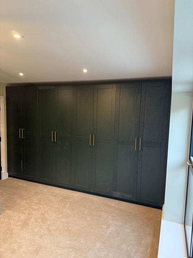 Navy shaker doors with brass bar handles, wall to wall