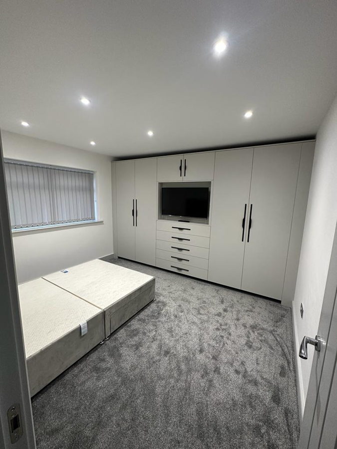 Cream wardrobes with a television recess and drawers under