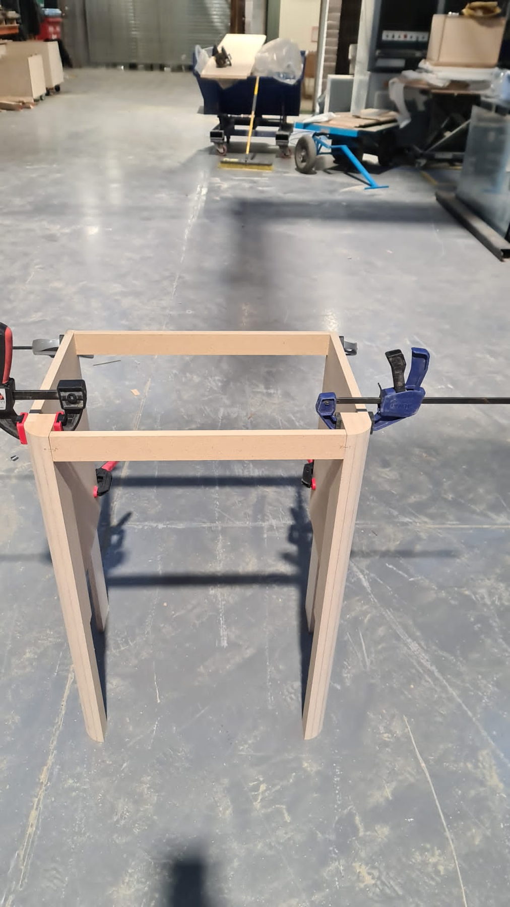 A timber table frame clamped up on the floor
