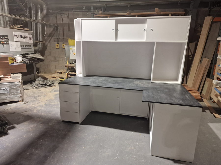 A desk run with overhead cupboards, built in the workshop
