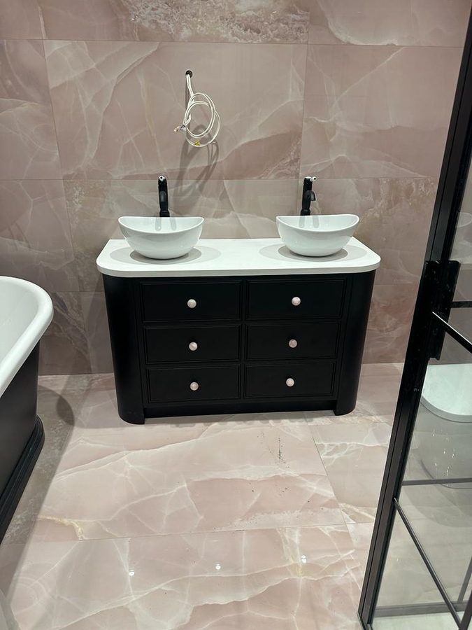 A curved-end double vanity with two vessel basins