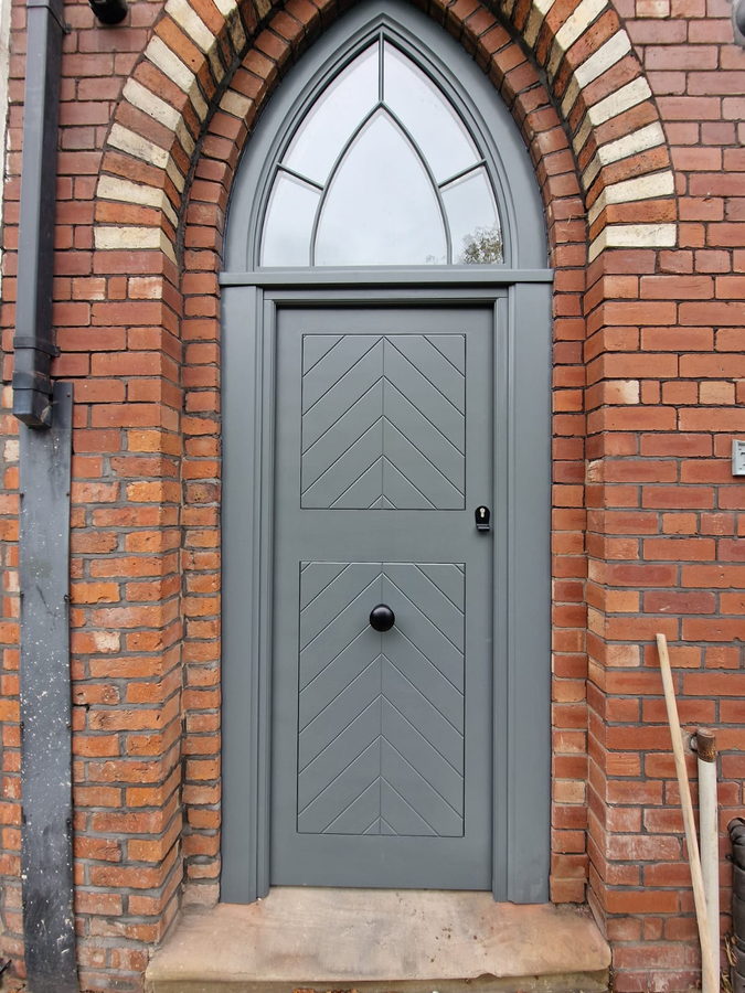 Straight on: chevron boards under a glazed gothic fanlight