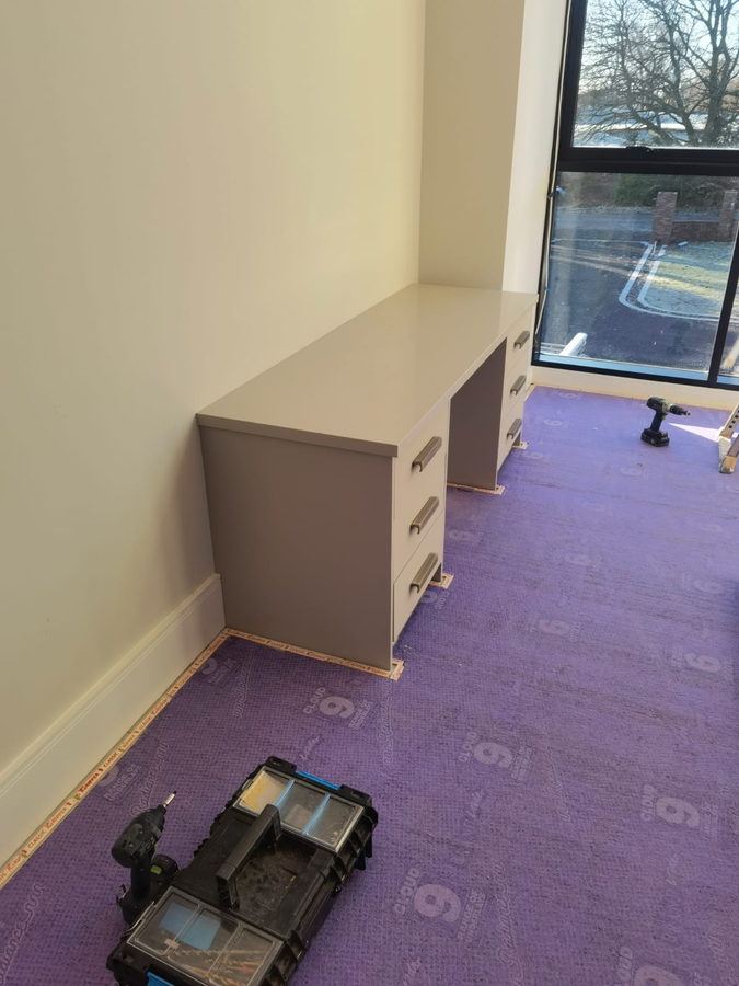 Desk and pedestal units against the glazing