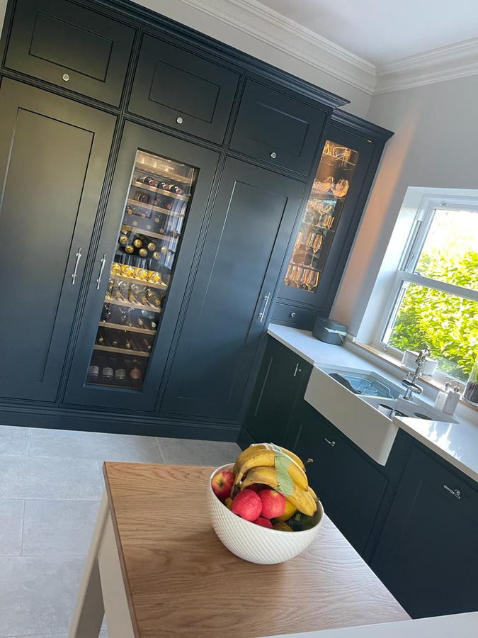 A lit glassware cupboard, integrated wine cabinet and butler sink in one run