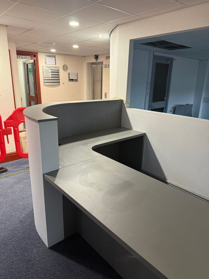 A curved reception counter in an office corridor