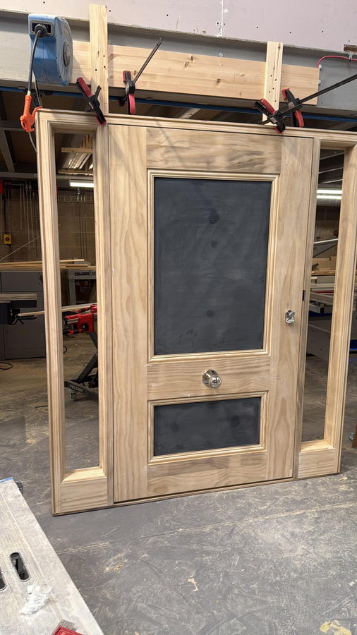 A glazed oak screen door clamped up on the workshop floor
