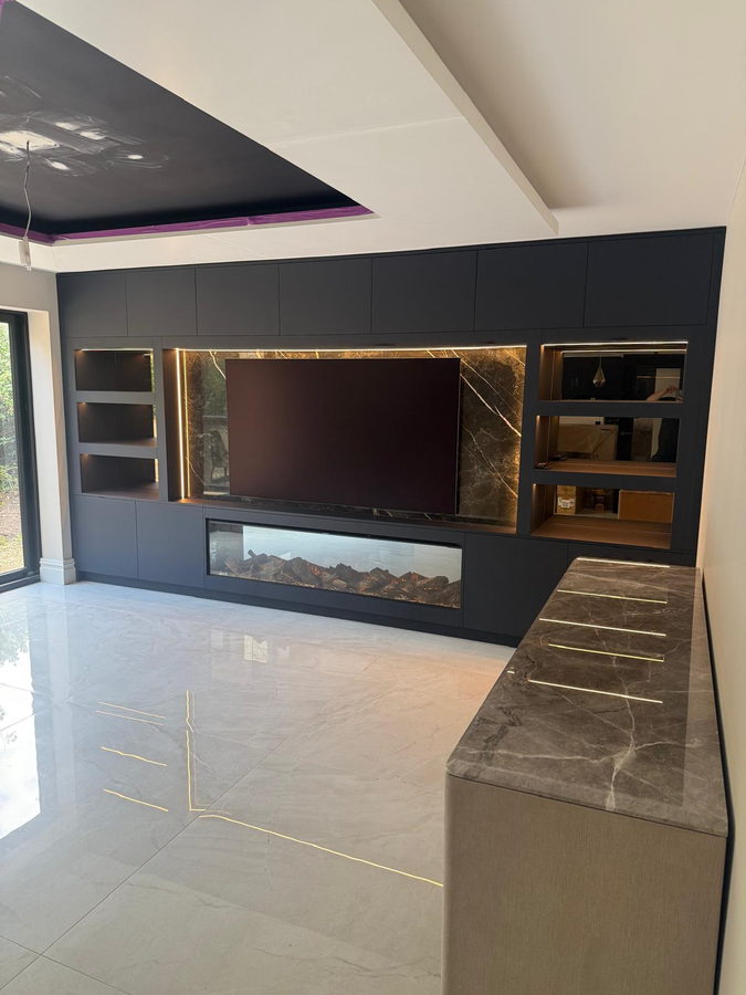 The finished wall: LED niches, a book-matched porcelain panel and a full-width electric fire
