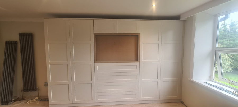 Cream panelled wardrobes with a central recess and painted returns