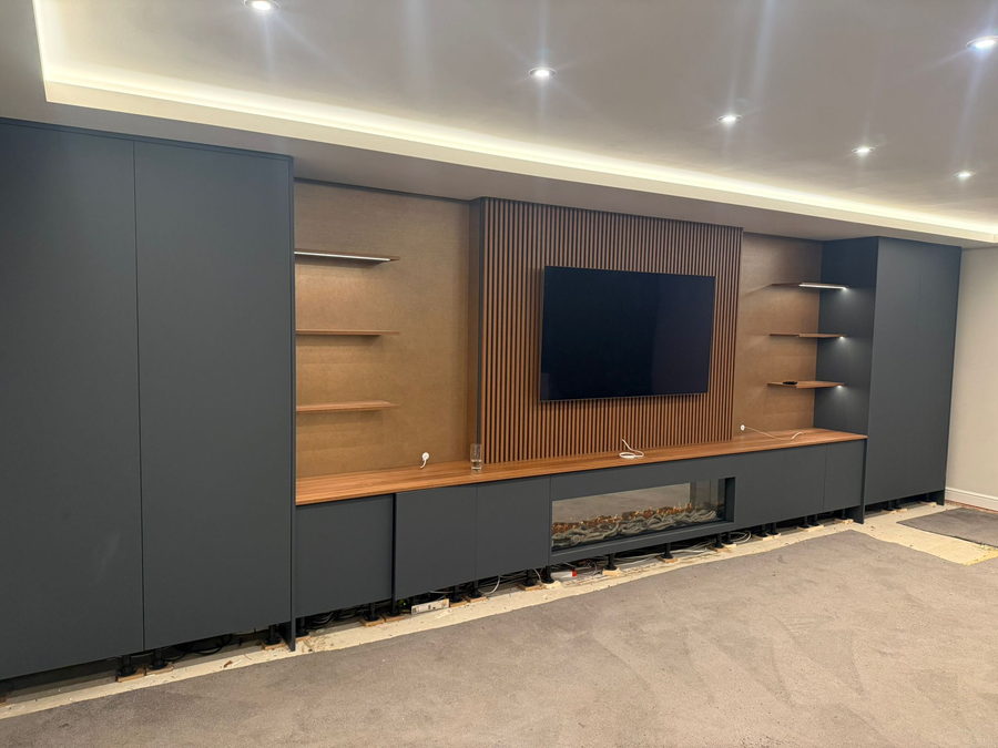 A fluted walnut panel behind the television, with a linear fire under