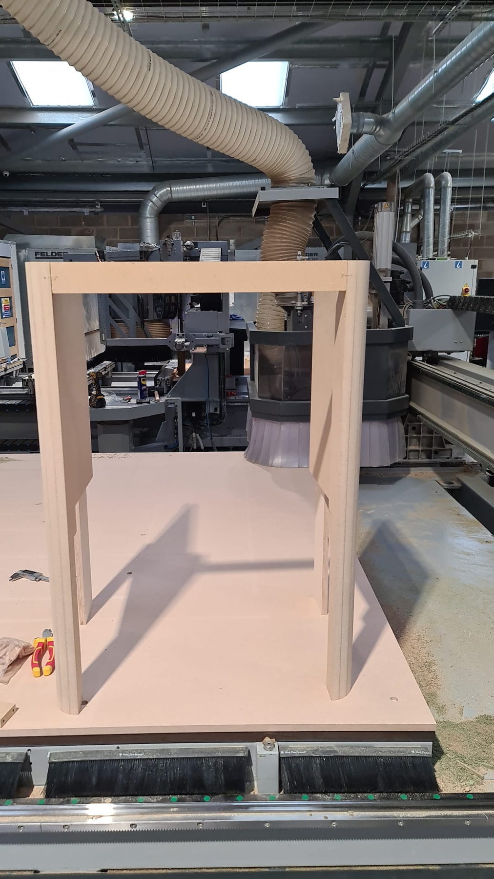 A machined leg assembly on the bed, extraction hose overhead