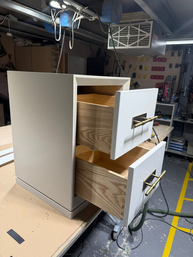 A cabinet with its oak drawer boxes and brass handles fitted