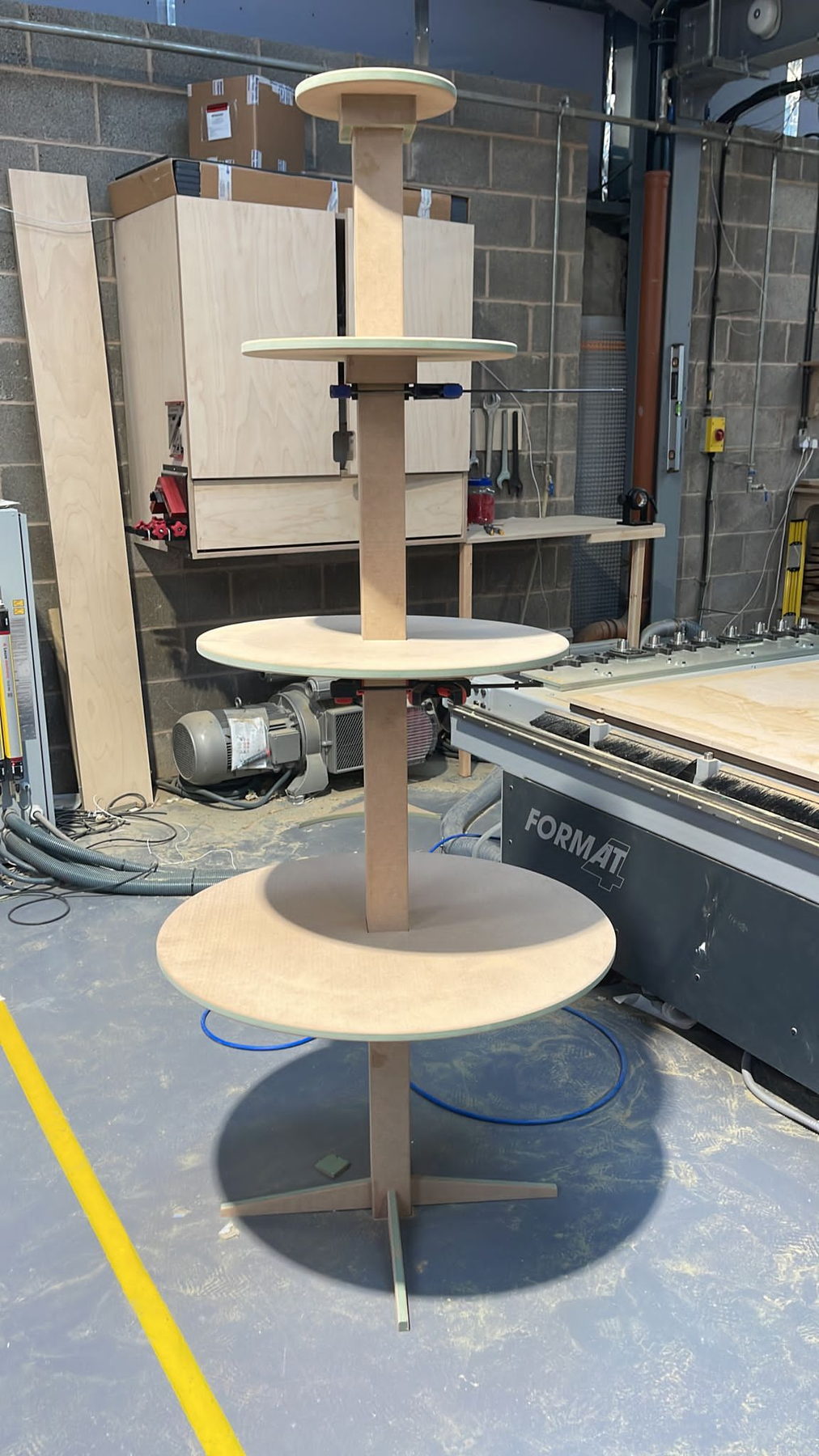 A machined display stand beside the sliding table saw