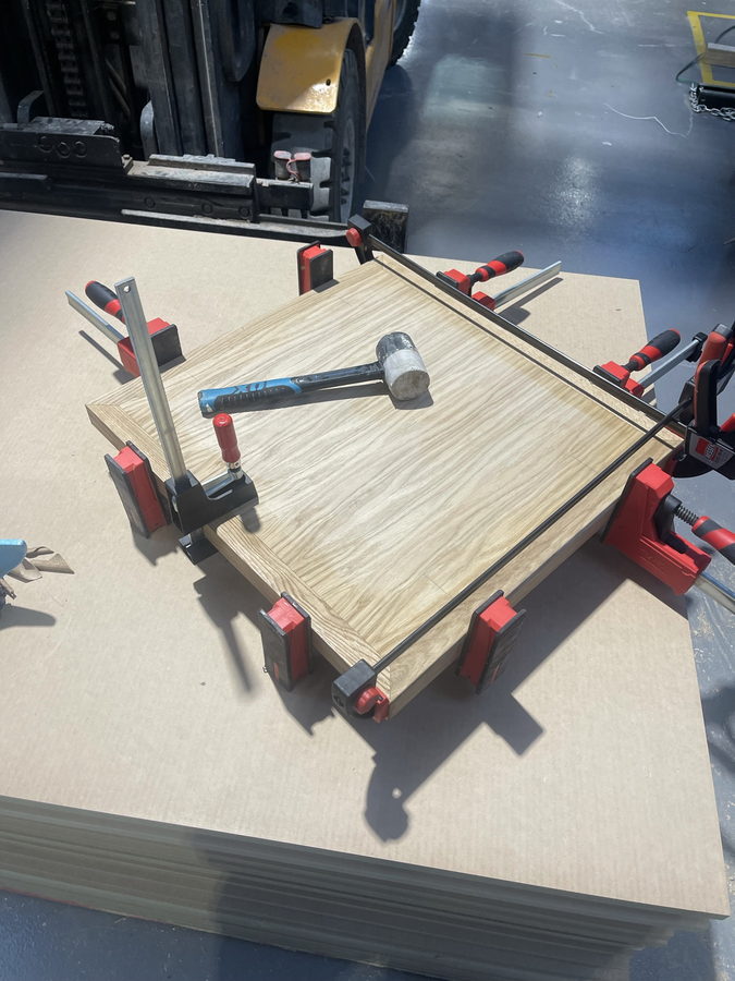 An oak panel clamped up while the edging goes on