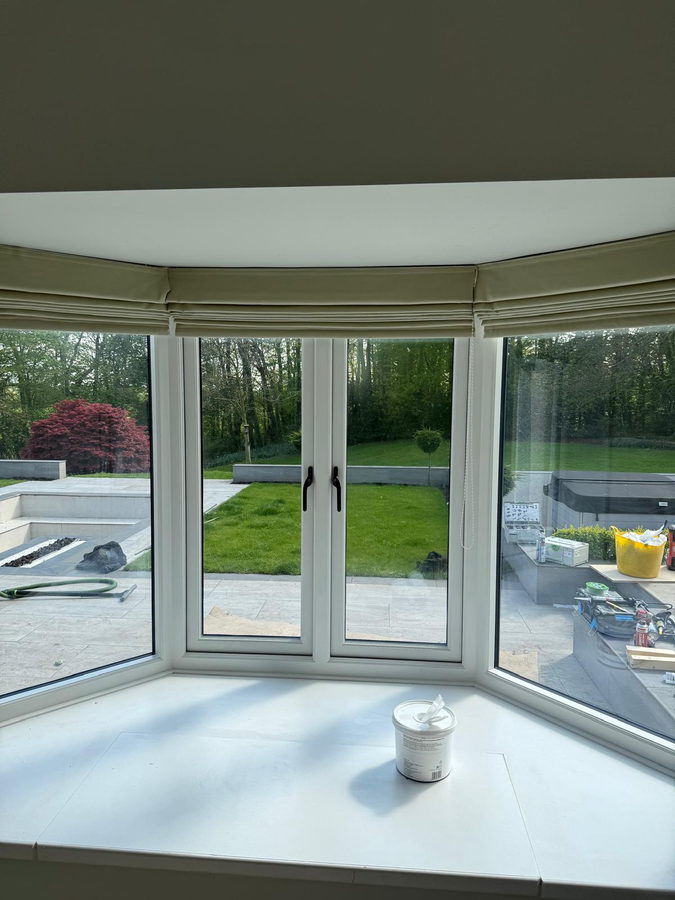 Broad painted window seat below curved casements